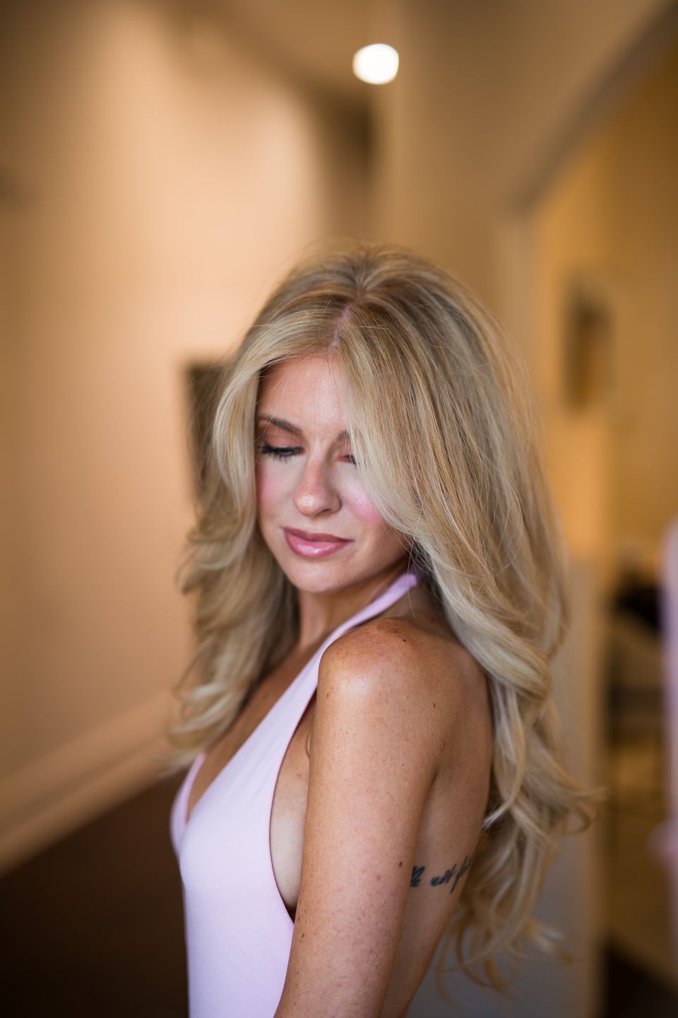 Soft, dimensional golden blonde waves in warm light at Studio Beige