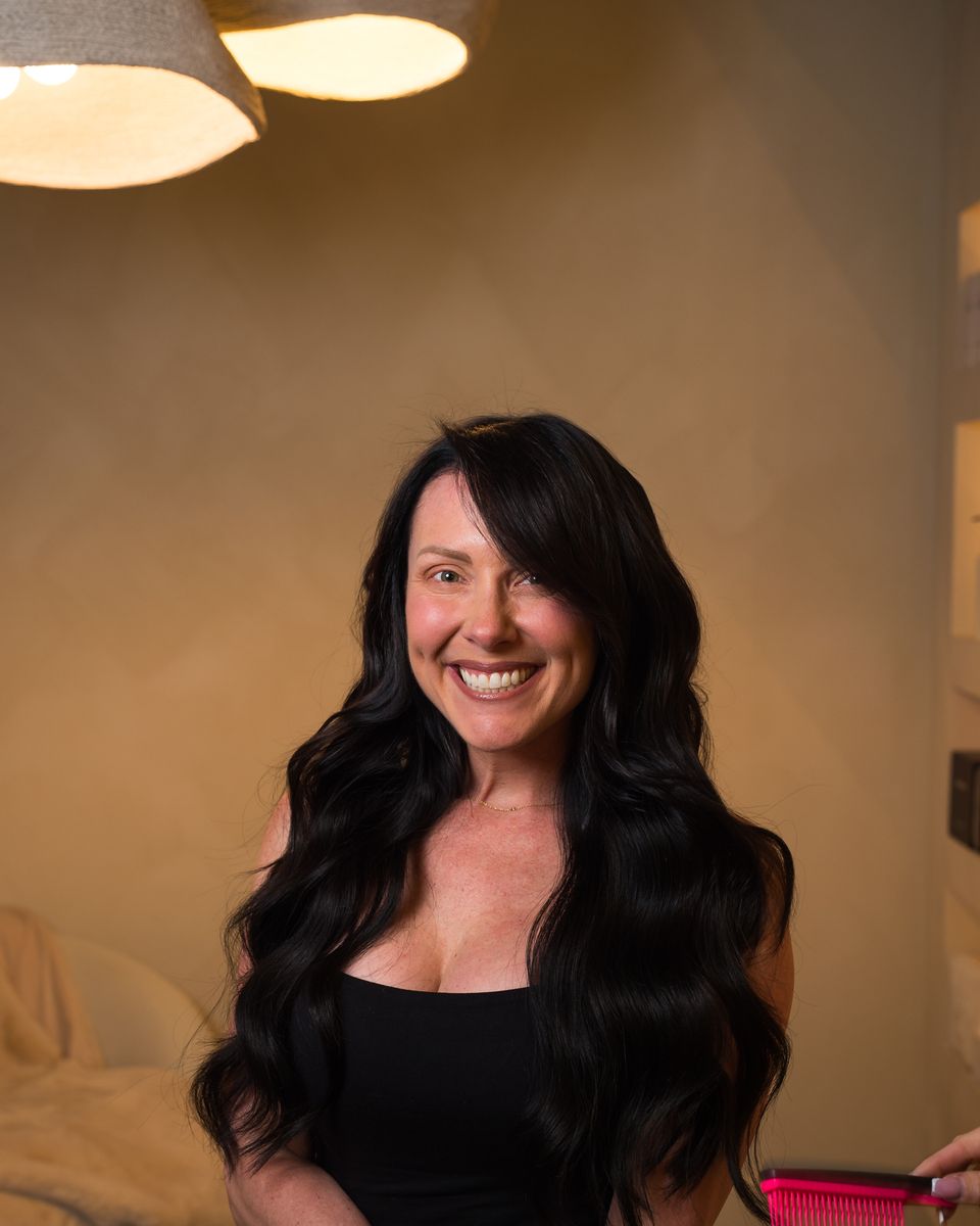 The same client with long, voluminous dark extensions after her install at Studio Beige