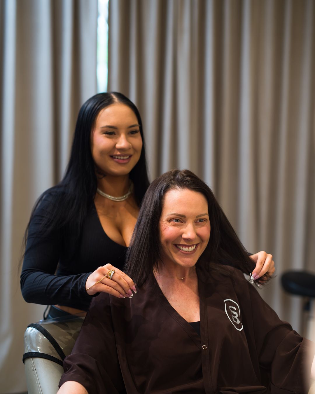 A Studio Beige stylist and a client smiling together in the consultation chair