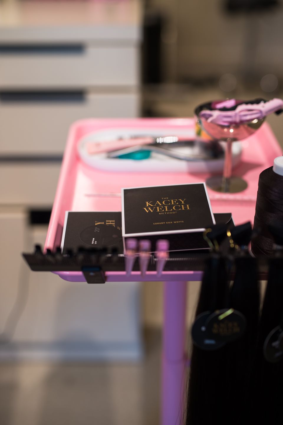 Kacey Welch Method weft boxes on a styling cart at Studio Beige