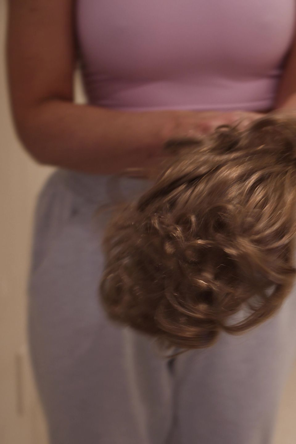 A Studio Beige stylist holding a curly men's hair system