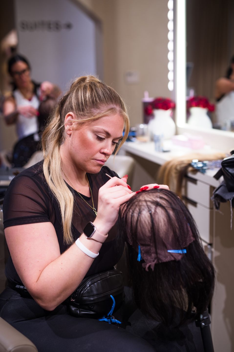 Stylist fitting a hair unit on a training head at a Studio Beige station