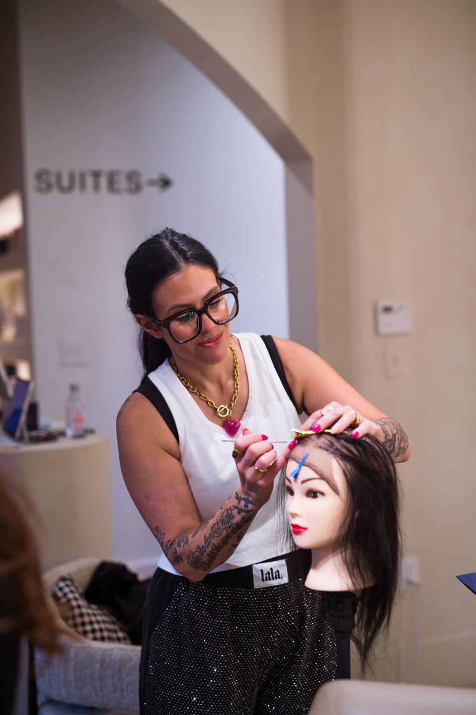 Stylist styling a hair unit on a training head inside Studio Beige
