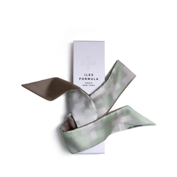 Iles Formula silk hair twilly in the Frivole sage-green print, draped over its white embossed gift box